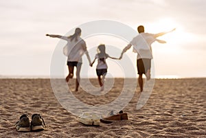 Happy asian family enjoy the sea beach at consisting father, mother,son and daughter having fun playing beach in summer vacation