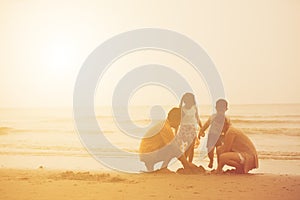 Happy Asian family enjoy together playing fun on the beach summer vacation sunset light in Thailand sea