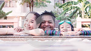 Happy asian family father mother and daughter smile in swimming pool.16:9 style