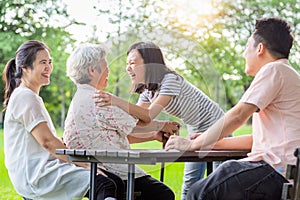 Happy asian family,father,mother with funny child girl play,laugh and hugging grandmother having fun together,smiling senior woman