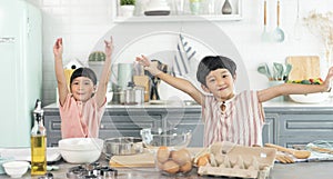 Happy asian family funny kids are preparing the dough, bake cookies in the kitchen