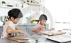 Happy asian family funny kids are preparing the dough, bake cookies in the kitchen