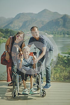 happy asian family with grandmother sitting on wheel chair