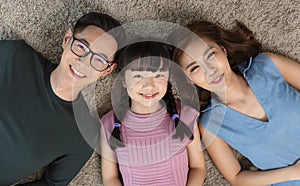 Happy Asian family lying on living room with happy and smile, top view