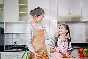 Happy Asian family. Mother and kid preparing healthy food and having fun in kitchen at home