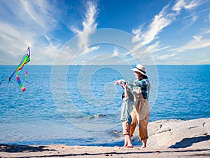 Happy Asian family of mother and son launch a kite into nature at the beautiful sky, mother and happy son in the sky during a