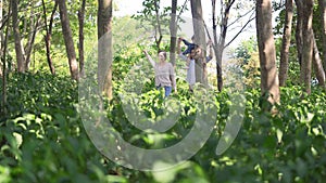 Happy asian family with one child walking in woods