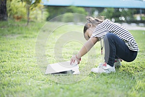 Happy asian family picnic. Daughters playing mobile phones and laptops having fun together while sitting alone on sunny day