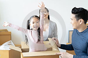 Happy Asian family playing with cardboard box in their new hous.having fun together at moving day. Moving Day Concept