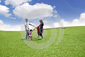 Happy asian family playing on the field