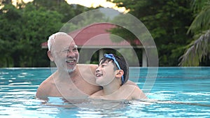 Happy asian family playing in pool.