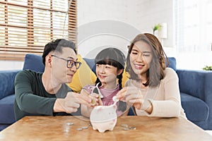 Happy Asian family saving money in piggy bank pig. investment for future concept
