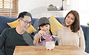 Happy Asian family saving money in piggy bank pig. investment for future concept