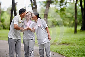 Happy Asian Family Showing Each Other Love and Concern in the Park while Walking for Exercise. Family Bonding Without Bounds,