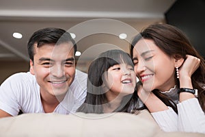 Happy asian family spending time together on sofa in living room. family and home concept.