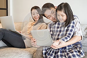 Happy asian family spending time together on sofa in living room. family and home concept