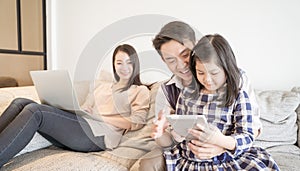 Happy asian family spending time together on sofa in living room. family and home concept.