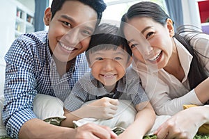 Happy asian family spending time together on sofa in living room. family and home concept.