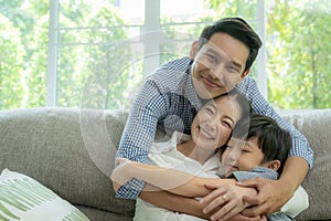 Happy asian family spending time together on sofa in living room. family and home concept.