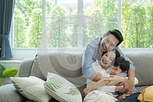 Happy asian family spending time together on sofa in living room. family and home concept.