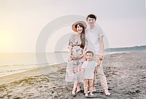 Happy  asian family standing on the beach  at