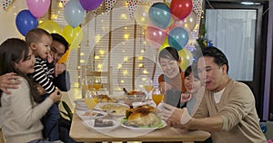 Happy Asian family taking selfie photo at a Christmas Party.