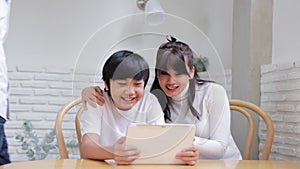 Happy Asian family talking video conference by computer together in living room , New normal lifestyle and activity technology, so