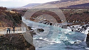 Happy Asian family travelers at hraunfossar waterfall in Iceland