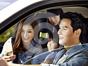 Happy asian family traveling by car