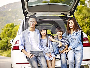 Happy asian family traveling by car