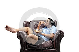 Happy asian fat man snacking donuts on plate in the couch