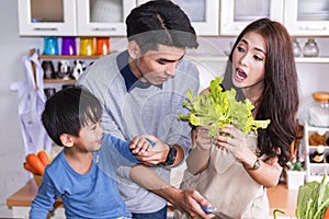 Happy asian father,mother,child standing and smile in kitchen