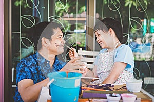 Happy asian Father `s day.Funny smiling father and her daughter painting and drawing with watercolor