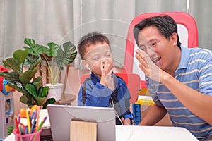Happy Asian father and son with tablet computer are making video call to mother or relatives at home, Family having fun making