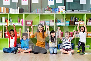 Happy Asian female teacher and mixed race kids in classroom,Kindergarten pre school concept photo