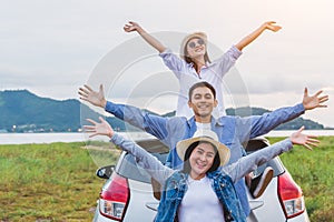 Happy Asian friends spread arms widely and breathed fresh air with happiness mood in on raod trip in car trunk. People lifestyle