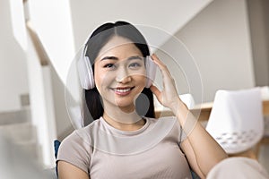 Happy Asian gadget user girl in headphones head shot portrait