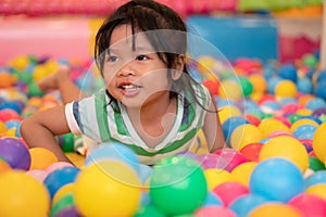 Happy Asian girl 4 years olds playing little colorful balls in pool ball. The concept of playing is the best learning for