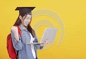 Happy Asian girl college student in Graduation cap  and holding laptop