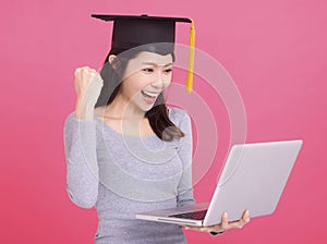 Happy Asian girl college student in Graduation cap  and holding laptop