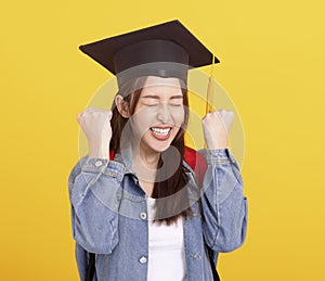 Happy Asian girl college student in Graduation cap  with success gesture