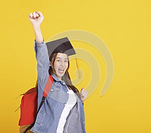 Happy Asian girl college student in Graduation cap  with success gesture