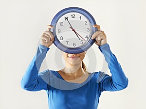 Happy asian girl holding big blue clock