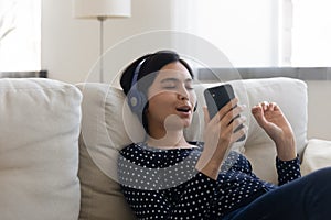 Happy Asian girl listen to music on cellphone in headphones