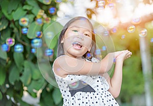 Happy asian girl play bubble soap at home