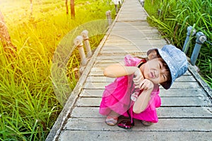 Happy asian girl relaxing outdoors with bright sunlight at the d