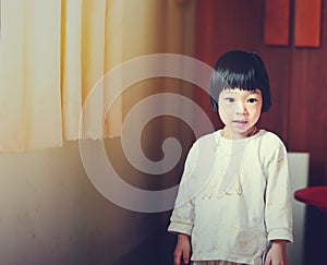 Happy Asian girl stading near window at home.