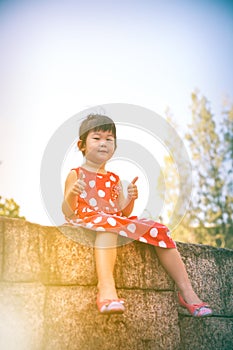 Happy asian girl with thump up and relaxing outdoors in the day