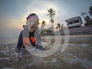 Happy asian girl wear life jacket and diving glasses,enjoy playing in the sea by the beach,tourist attractions at Kui Buri,