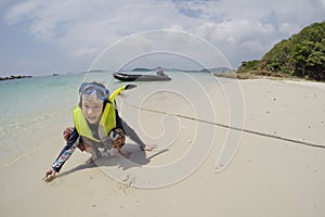 Happy asian girl wear life jacket,mask and snorkel,enjoy playing sand on the beach,tourist attractions at Koh Samaesarn,Chon Buri, photo